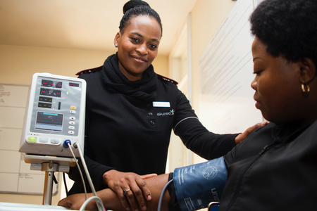 Care provider performing blood pressure screening on patient