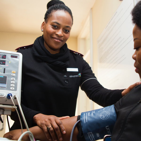 Care provider performing blood pressure screening on patient