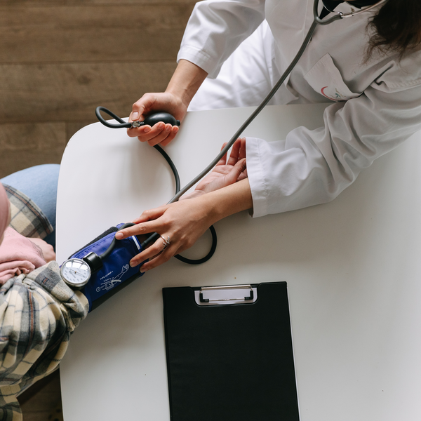 Care provider performing blood pressure screening on patient